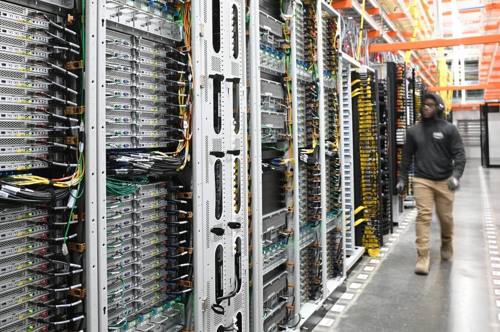 Open racks fitted with high-density patch panels and colour-coded patch leads, managed with vertical cable organisers.